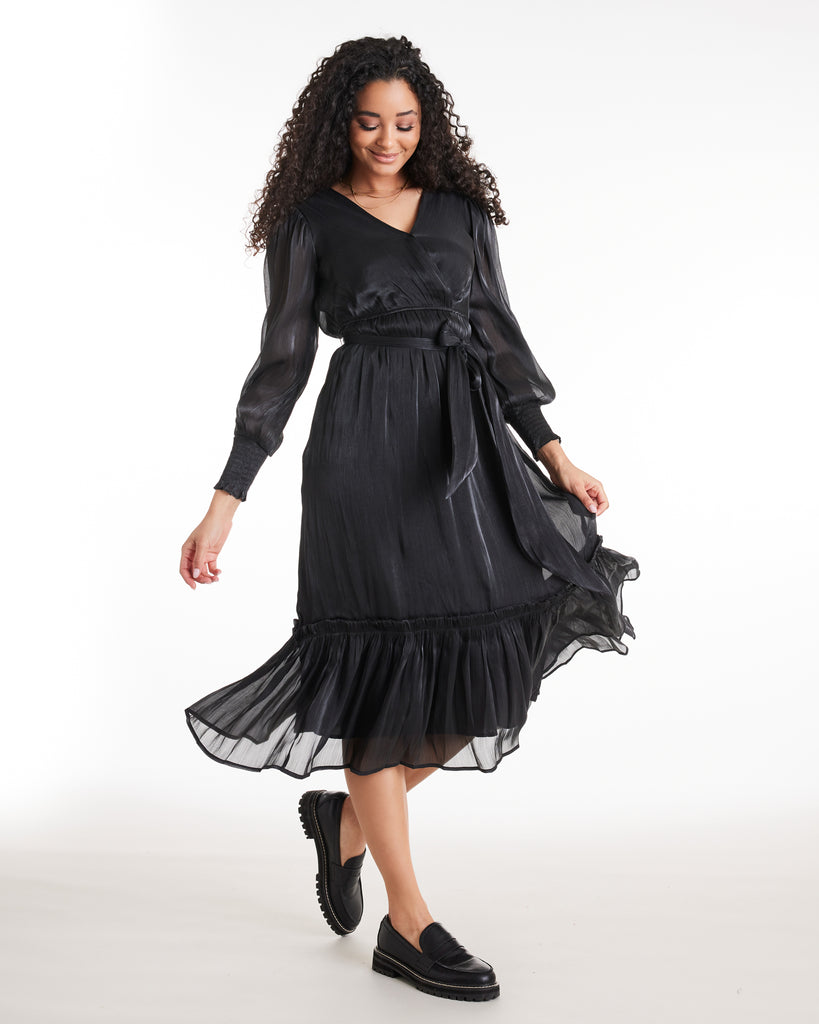 Woman in a long sleeve, black, midi-length dress