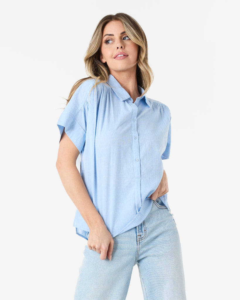 Woman in a blue short sleeved, collared, button-down