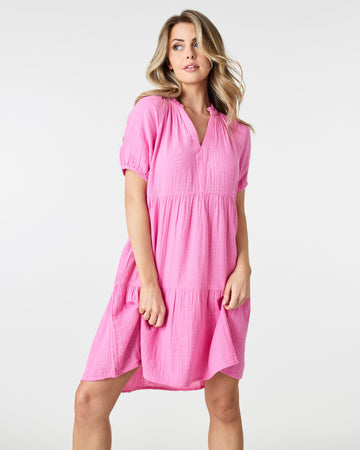 Woman in a pink short sleeve, tiered, mini-dress