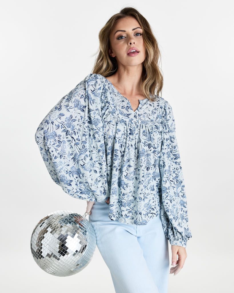 Woman in a blue floral print, long sleeve blouse