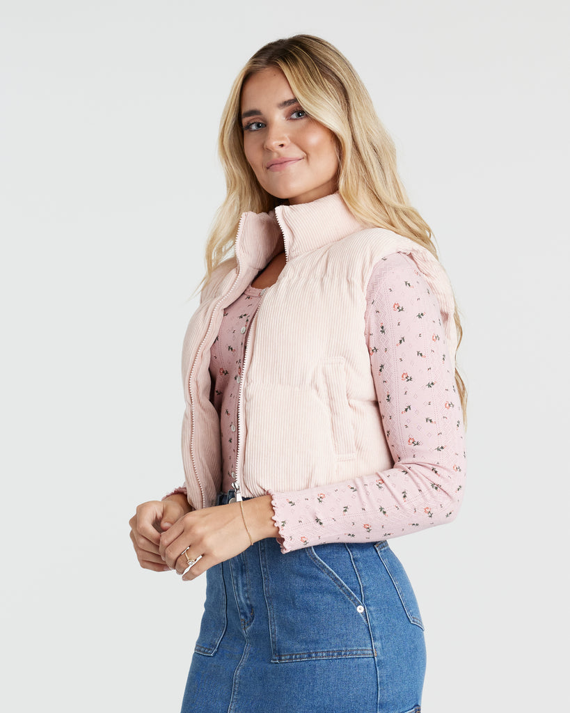 Woman in a pink cropped puffer vest