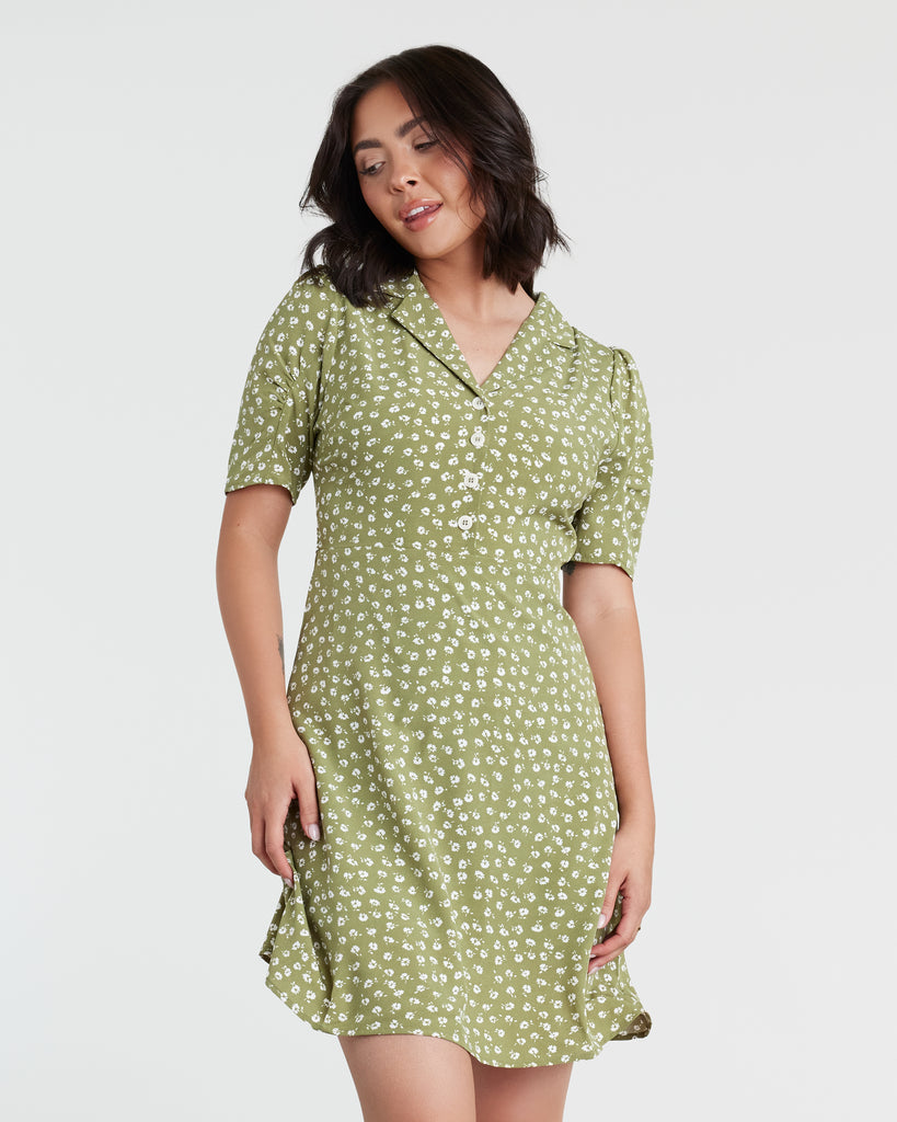 Woman in a green with white polka dot, short sleeve mini dress