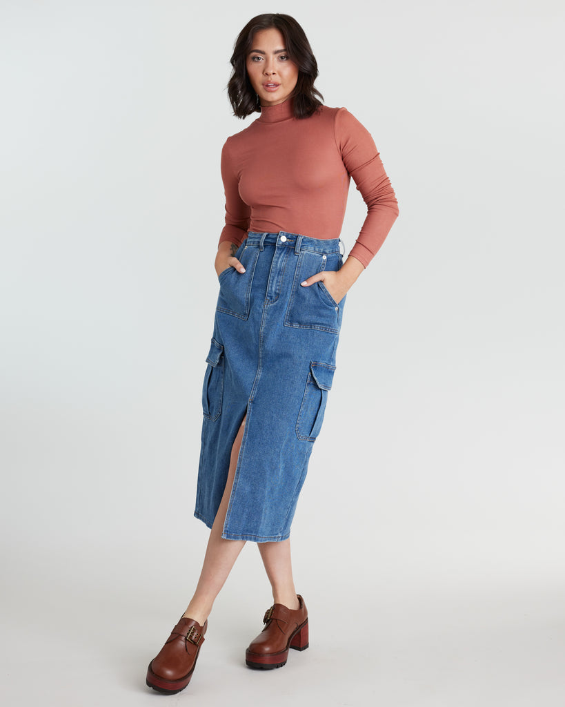 Woman in blue denim, midi-length skirt with a front slit