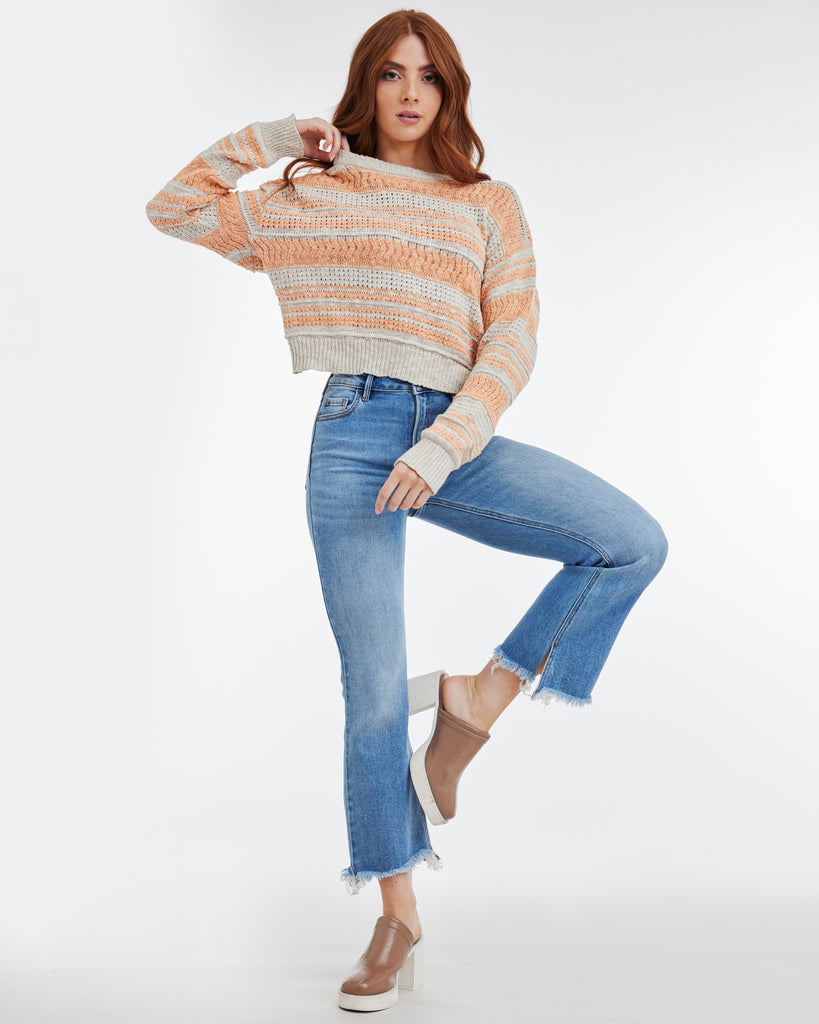 Woman in an orange and gray striped long sleeve sweater