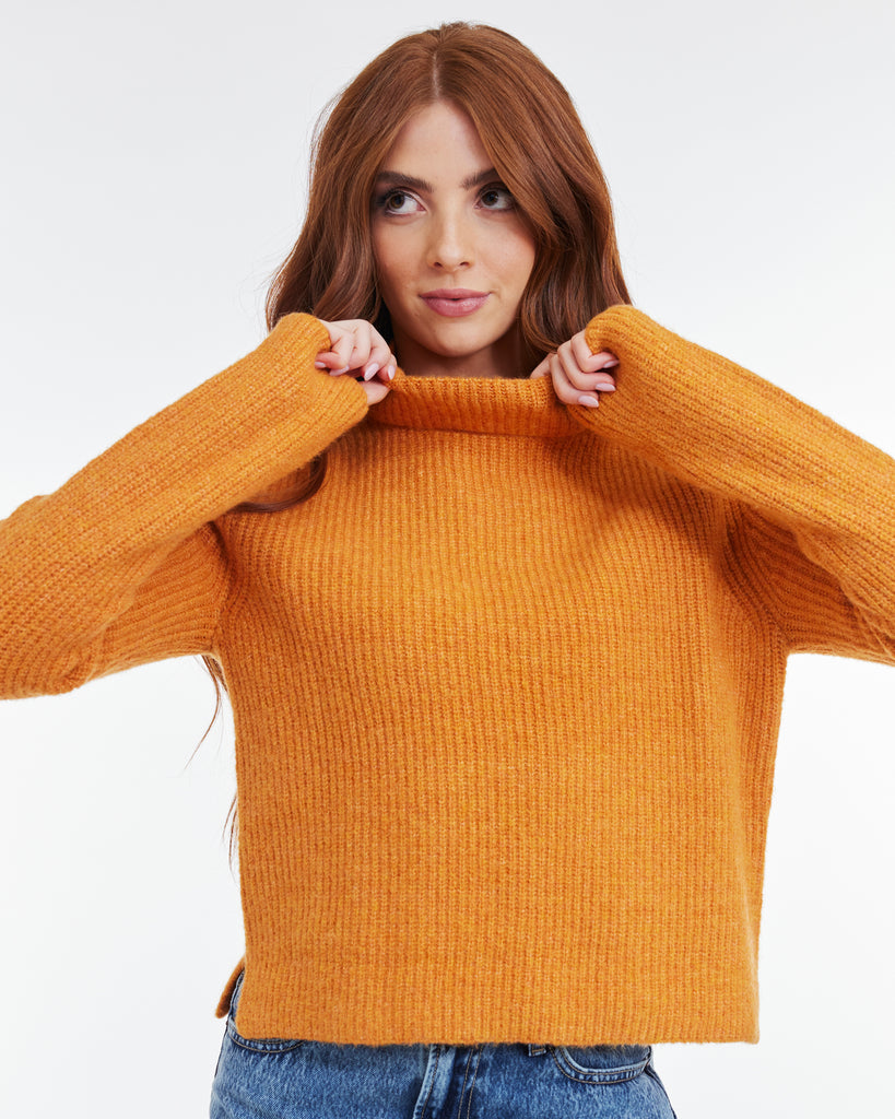 Woman in an orange, long sleeve, turtleneck sweater