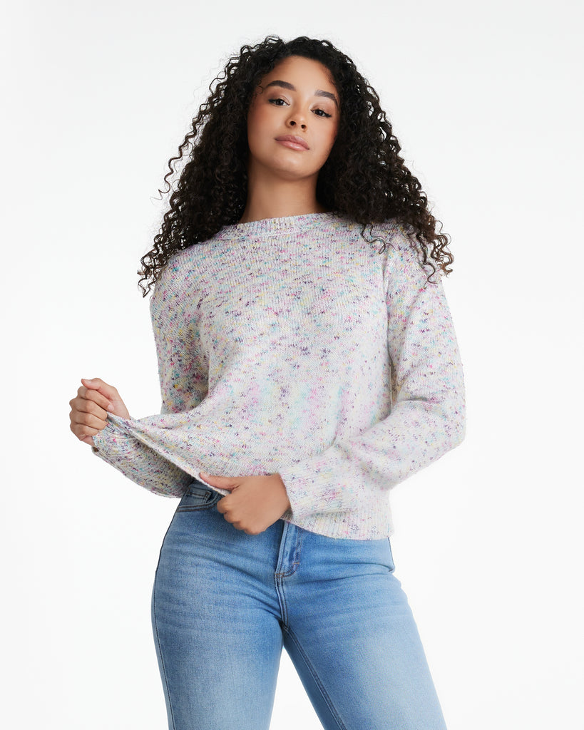 Woman in a white with blue and purple dot, long sleeve sweater