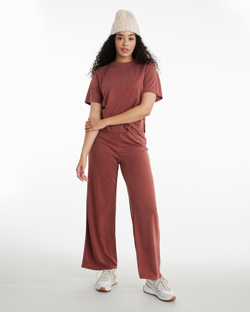 Woman in rust colored, cropped, lounge pants