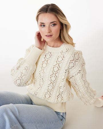 Woman in an ivory long sleeve sweater