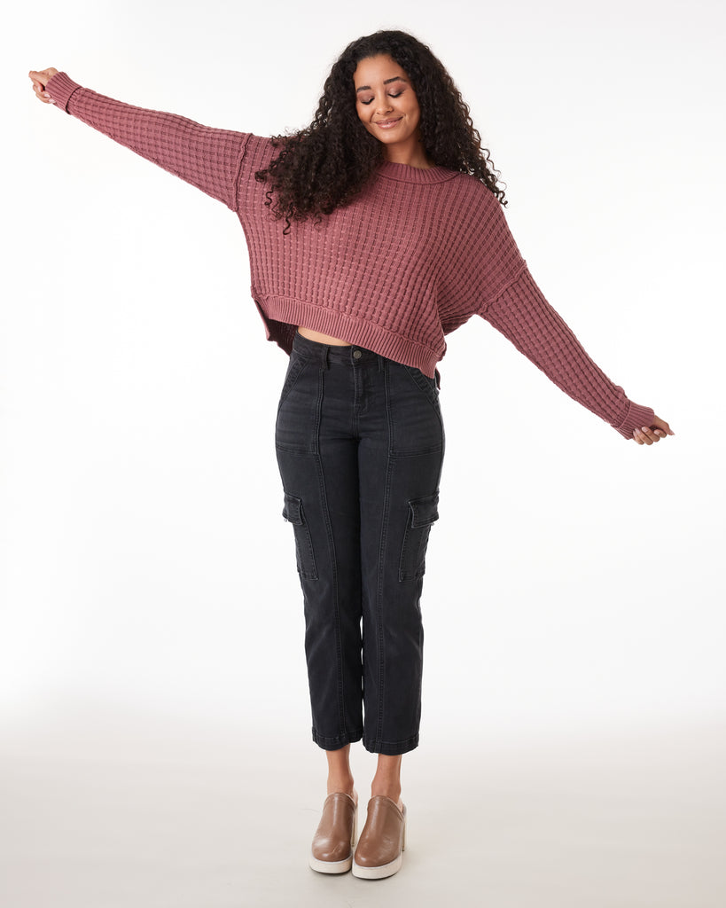 Woman in a dark pink long sleeve textured sweater