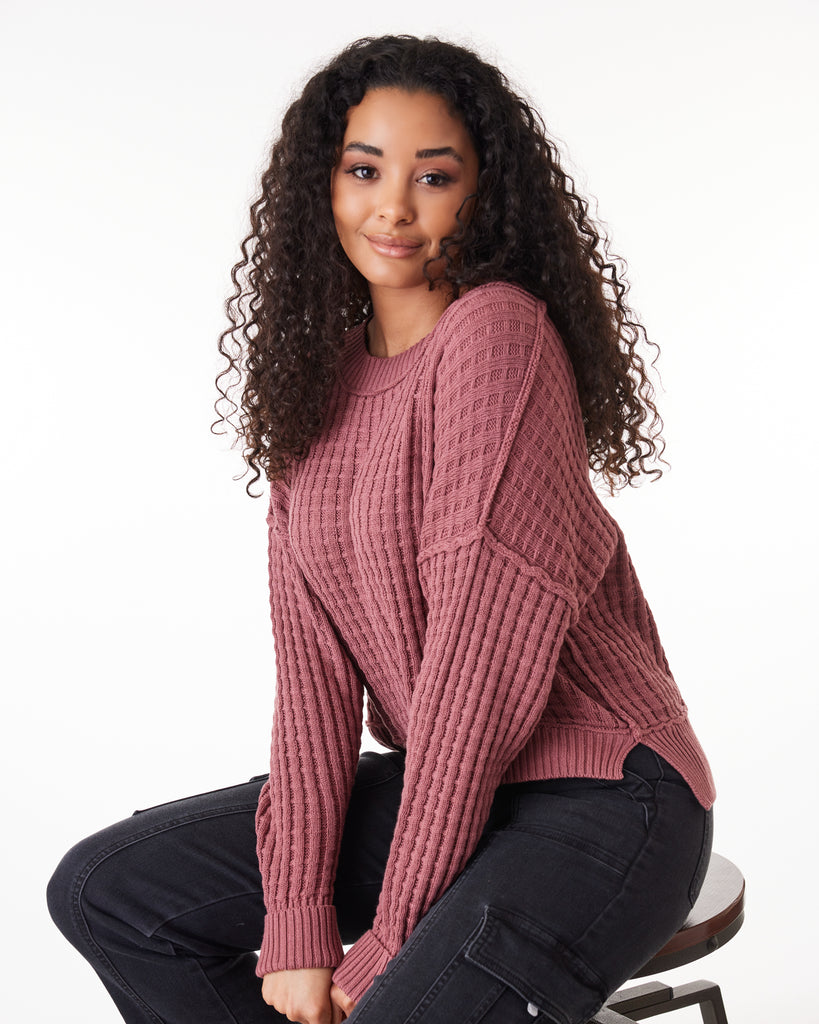Woman in a dark pink long sleeve textured sweater