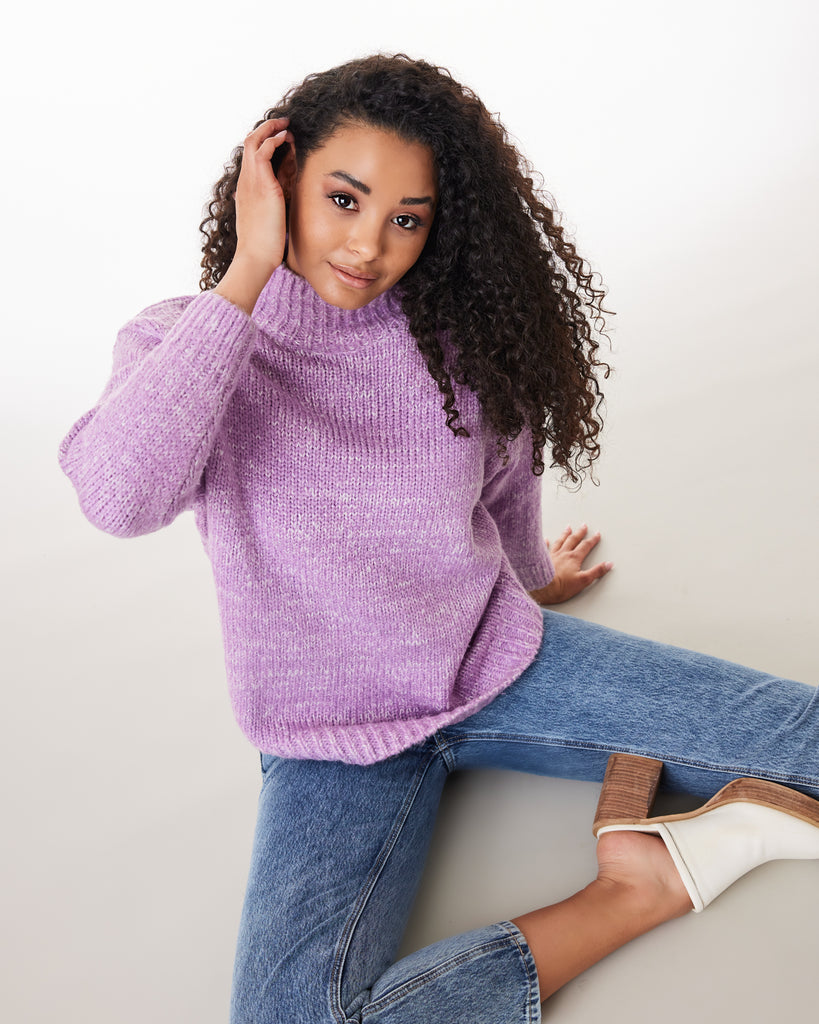 Woman in a purple long sleeve mock-neck sweater
