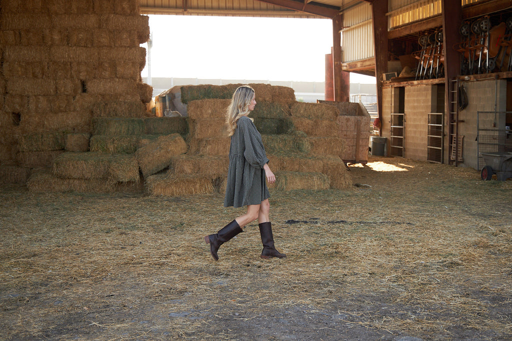 A women in a barn wearing a dress.